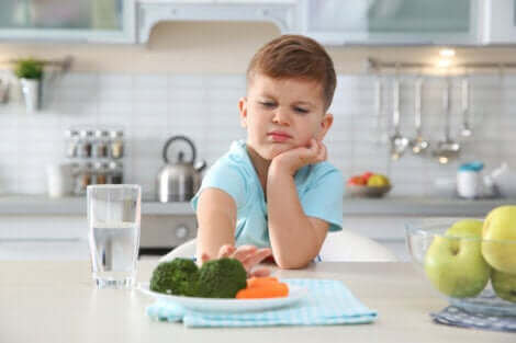 Un petit garçon qui refuse de manger son assiette. 