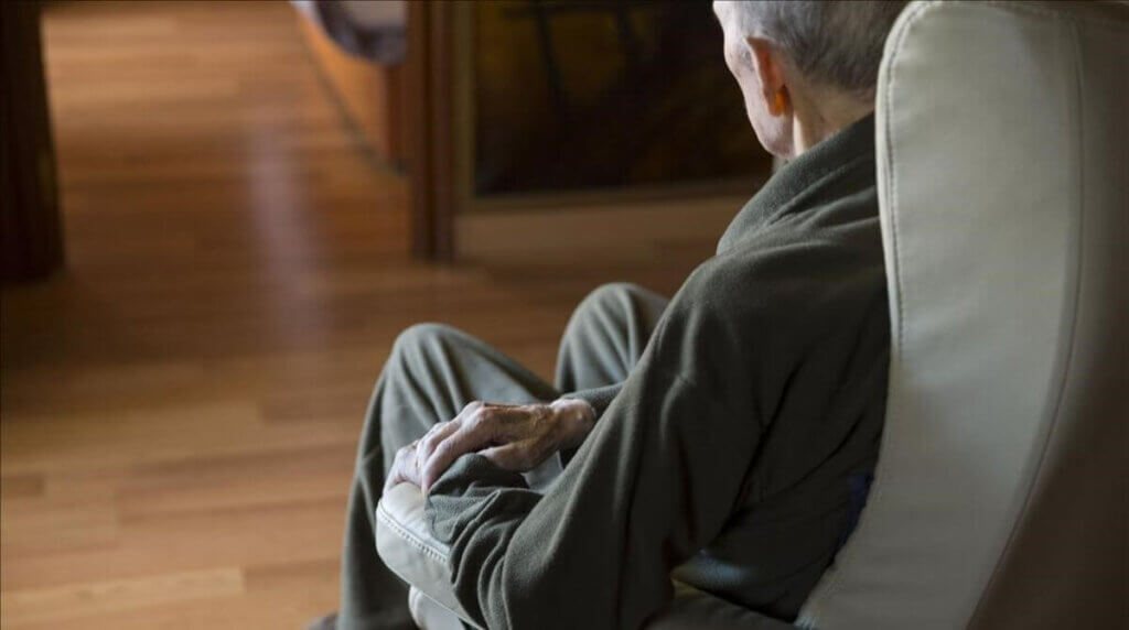 Un homme âgé sur un fauteuil. 