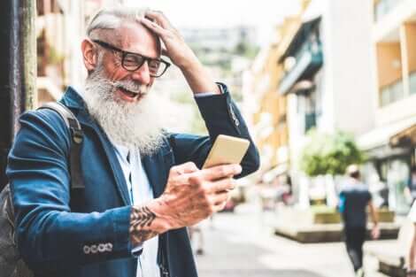 Un homme âge qui regarde son téléphone portable. 