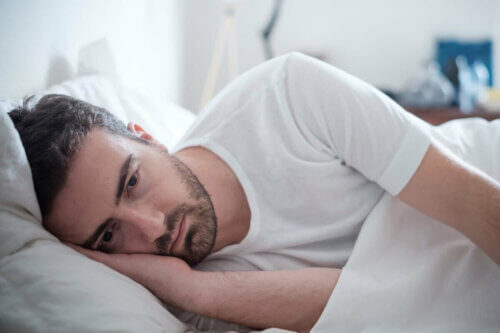Un homme anxieux au lit. 