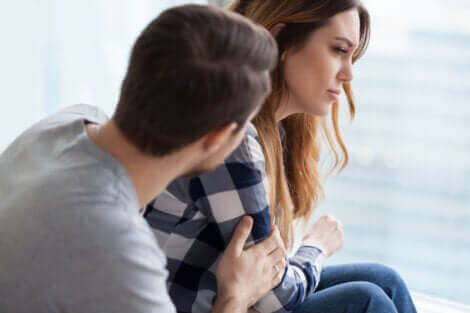 Un homme qui console une femme qui pleure. 