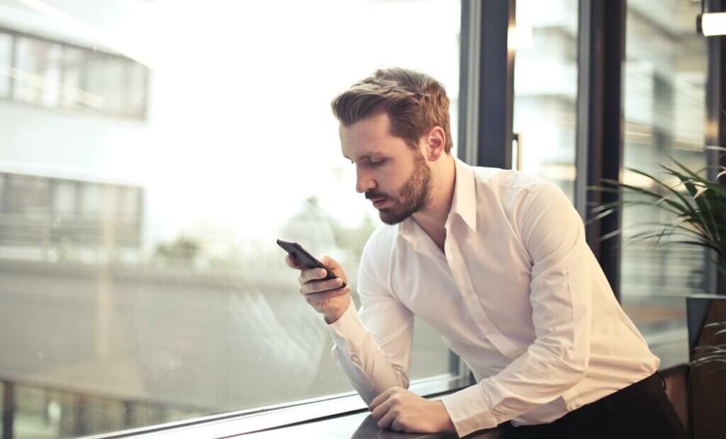 Un homme avec un téléphone portable en main.