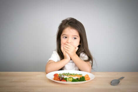 Une petite fille qui refuse de manger son assiette.