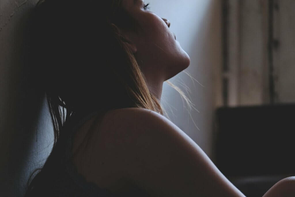 Une femme assise dans le noir.