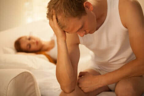 Homme stressé assis sur son lit.