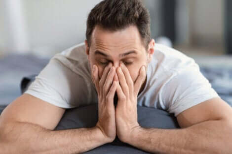 Un homme allongé qui se frotte les yeux. 