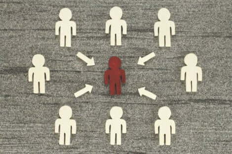 Groupe de silhouettes humaines blanches qui entourent une silhouette rouge. 