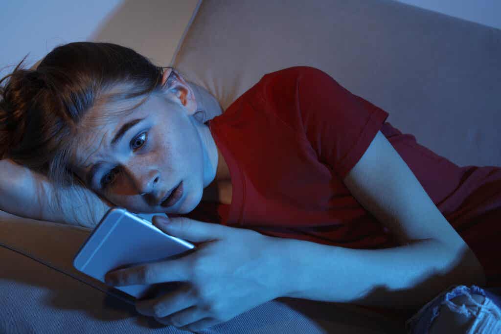 Ado qui regarde son téléphone effrayée. 