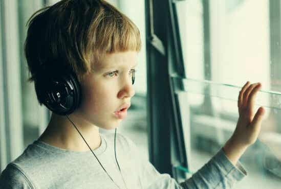 Un jeune garçon qui écoute de la musique avec un casque. 