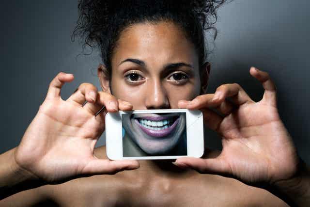 Une femme qui tient un téléphone entre ses mains.