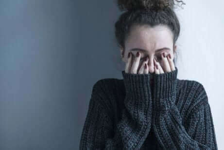 Une femme qui se cache les yeux. 
