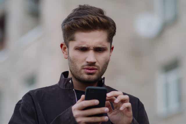 Un homme qui regarde son téléphone.