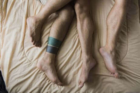 Des jambes d'hommes sur un lit.