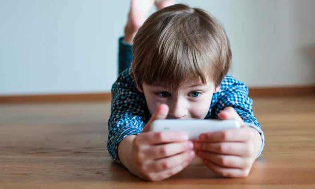 Un enfant qui joue sur un smartphone.