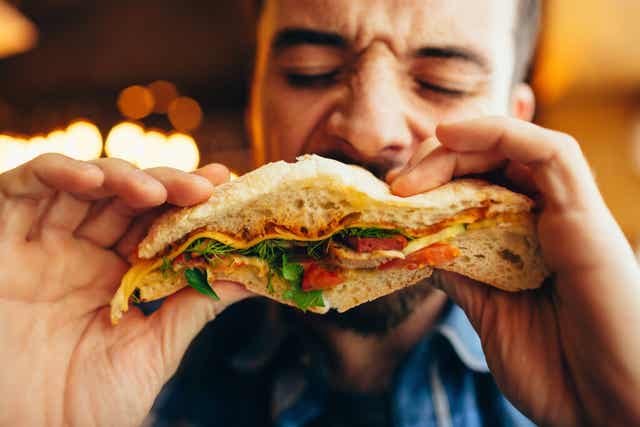 Un homme qui mange un sandwich. 