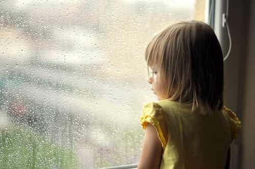 Petite fille qui regarde par la fenêtre.