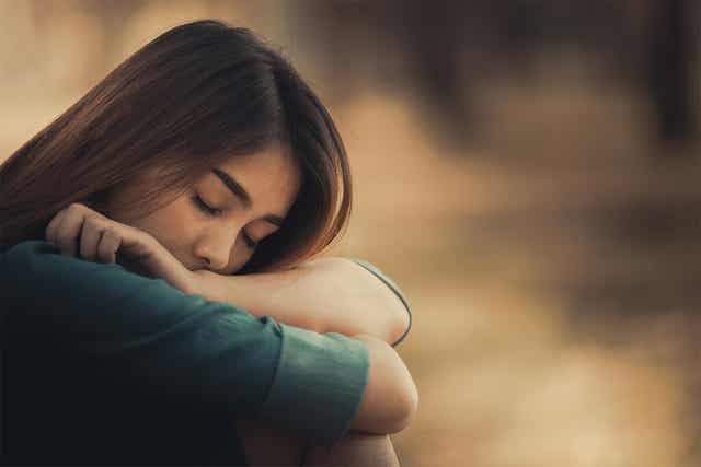 Une femme triste assise.