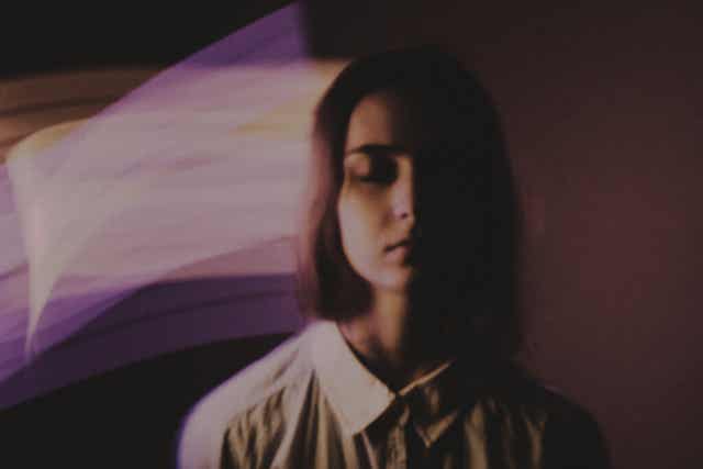 Une femme, les yeux fermés.