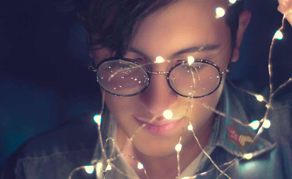 Un jeune homme avec une guirlande de lumières.