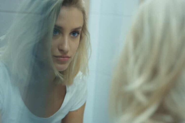 Une femme qui se regarde dans le miroir.