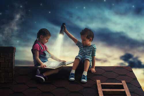 Deux enfants qui regardent un livre sur le toit d'une maison;