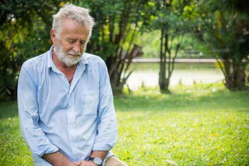 Un homme âgé assis dans l'herbe. 
