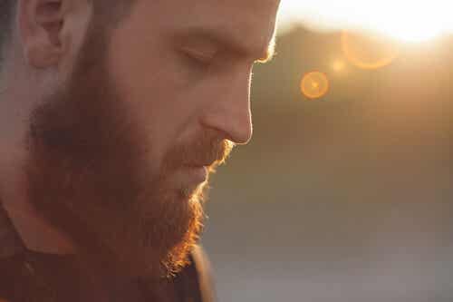 Un homme barbu qui ferme les yeux. 