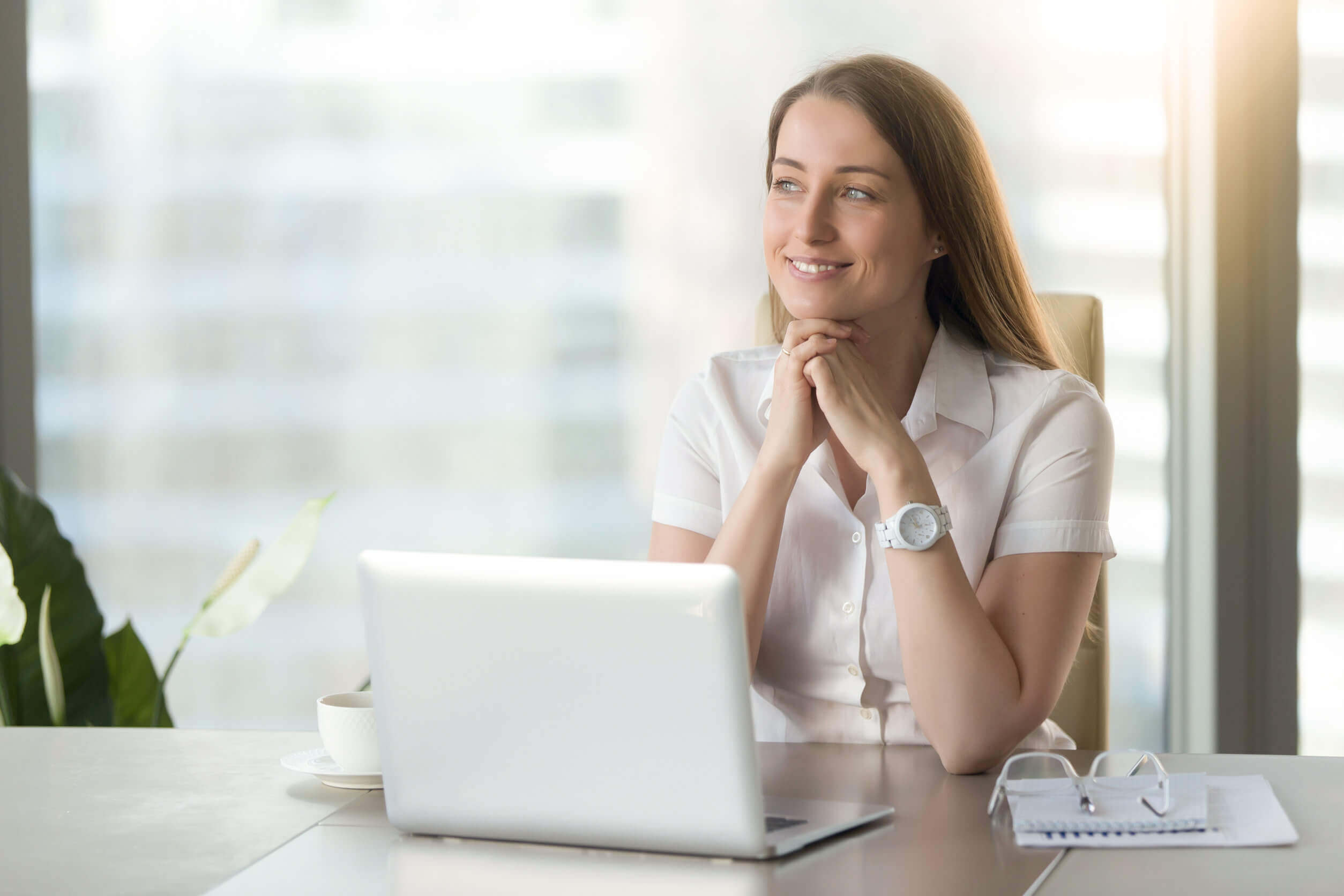 femme souriant devant son bureau