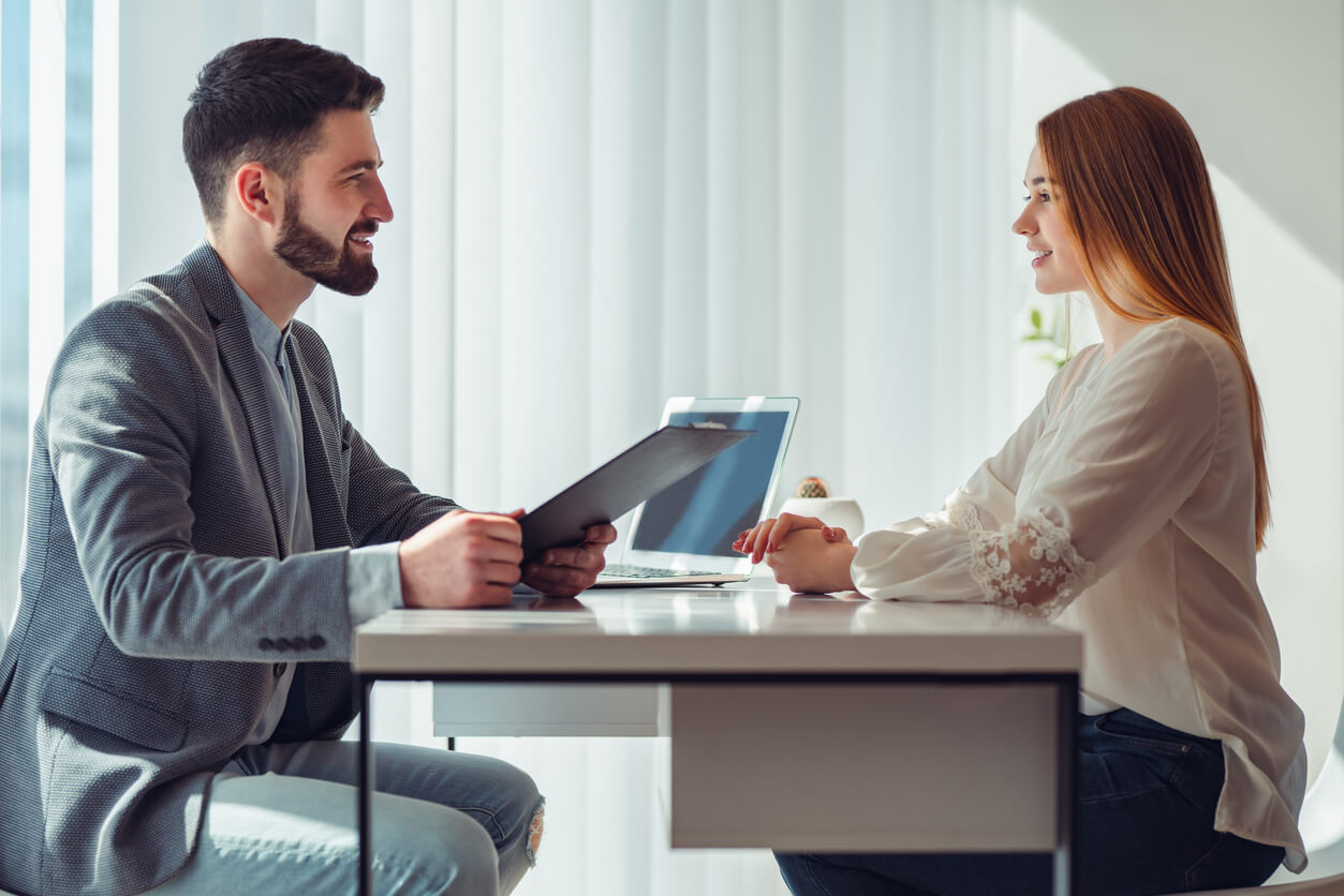 Femme nerveuse regardant le manager lire son CV lors d'un entretien d'embauche au bureau. Vue de côté